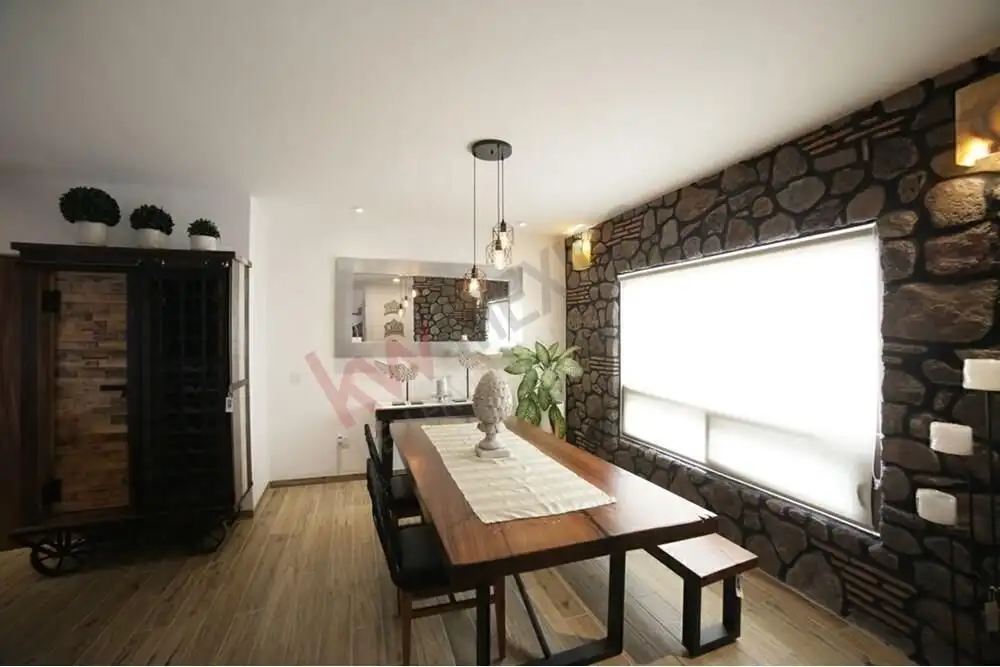 Bright dining room with stone accent wall and large window.