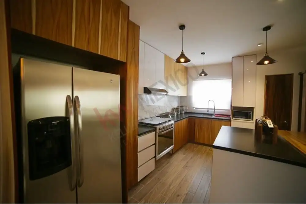 Spacious kitchen with stainless steel appliances, wooden cabinets, and ample counter space in a beau.