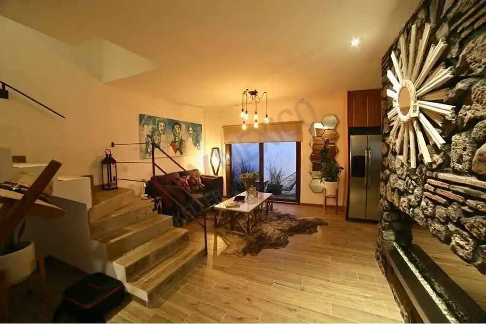 Cozy living room with modern decor, stone fireplace, and large window overlooking the cityscape.