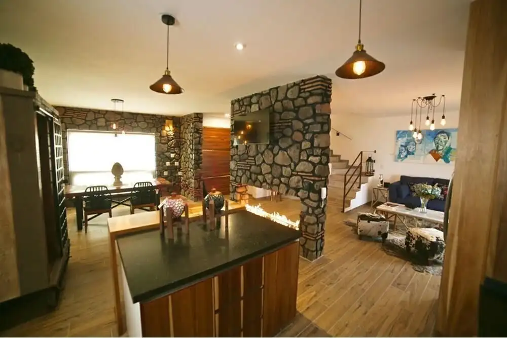 Spacious living area featuring a stone accent wall, modern furniture, and warm lighting in a beautif.
