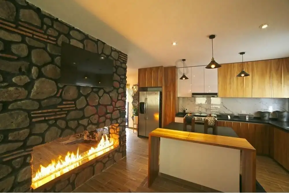 Stylish living room with stone fireplace and open kitchen in a modern home.