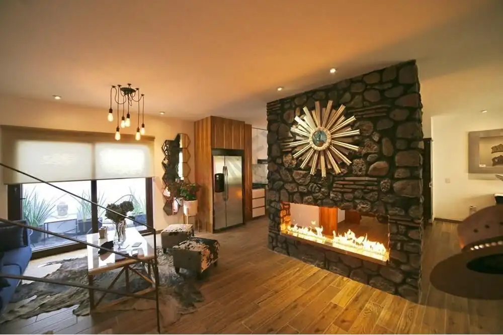 Inviting living room featuring a stone fireplace, stylish furniture, and warm lighting for a comfort.