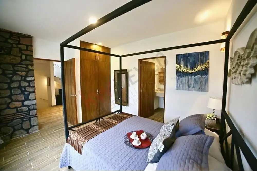 Cozy bedroom featuring a stylish four-poster bed, contemporary artwork, and natural wood accents in.