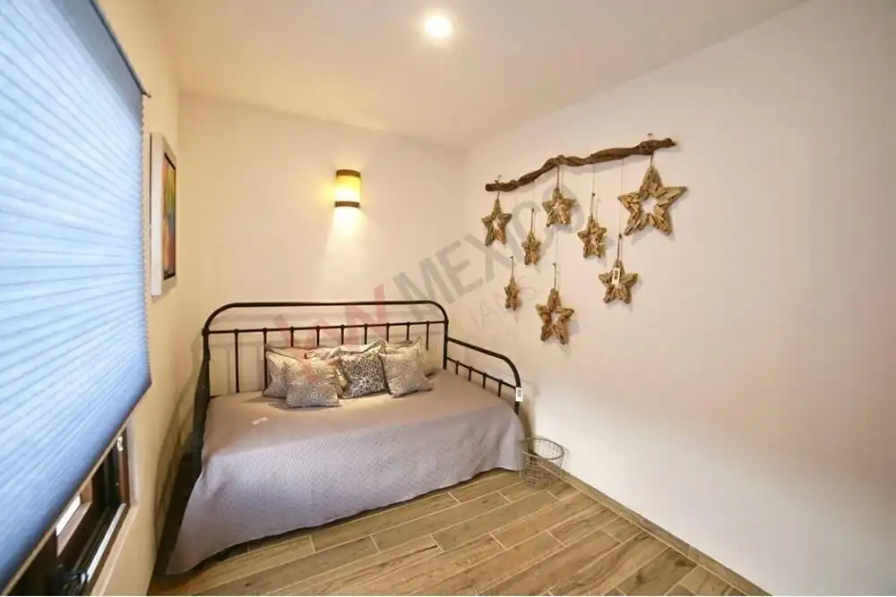 Interior view of a bedroom with a metal bed and star-shaped wall decorations in San Miguel de Allend.