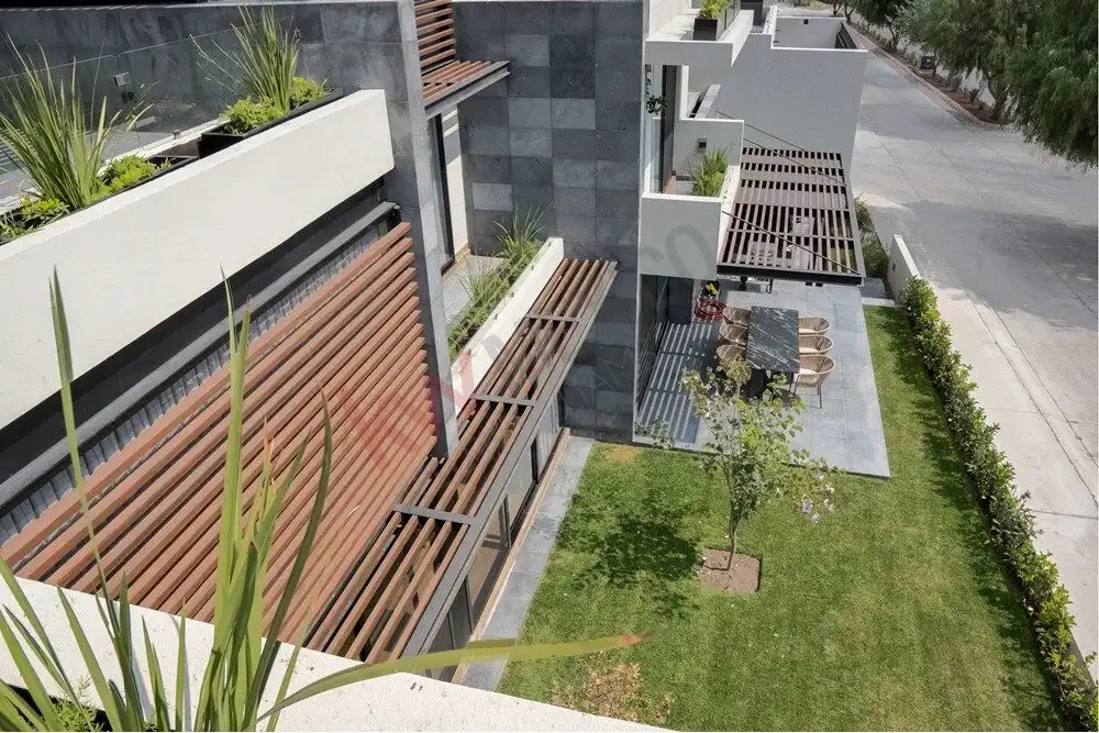 Contemporary home with outdoor seating and lush garden in Ventanas Golf Club, San Miguel de Allende.