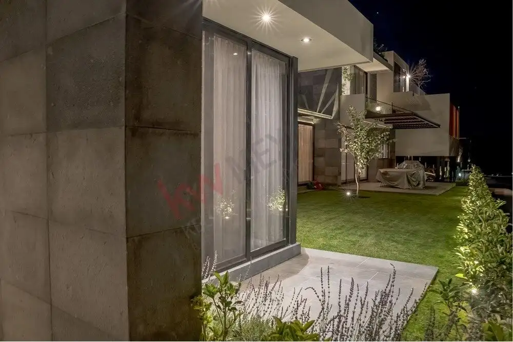 Modern luxury home with large glass doors and landscaped garden in Ventanas Golf Club.