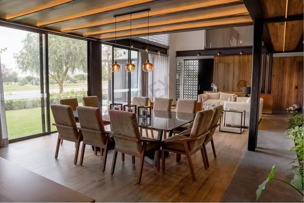 Elegant dining room with modern decor and large windows overlooking the golf course. Perfect for fam.