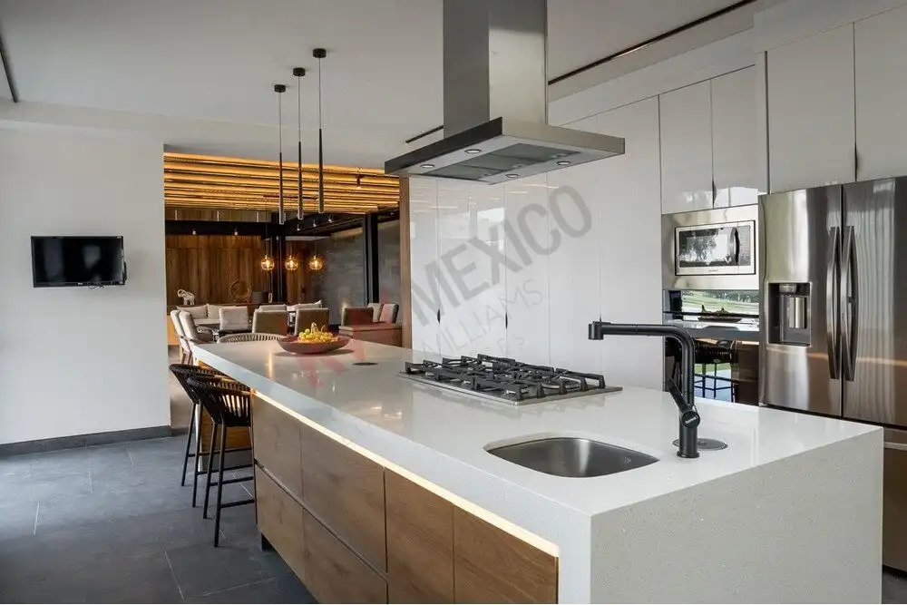 Spacious kitchen with sleek white countertops, stainless steel appliances, and a central island in a.