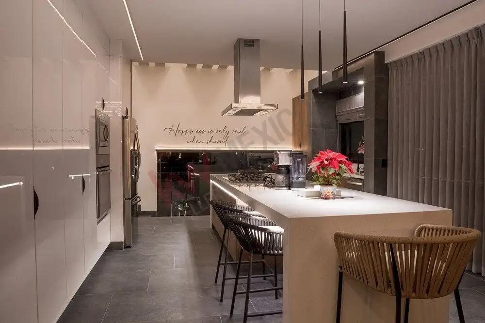 Modern kitchen with sleek design, white cabinetry, and a central island with seating.