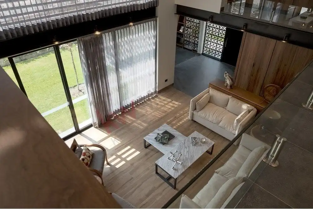 Elegant living room with modern decor and large windows in Ventanas Golf Club property.