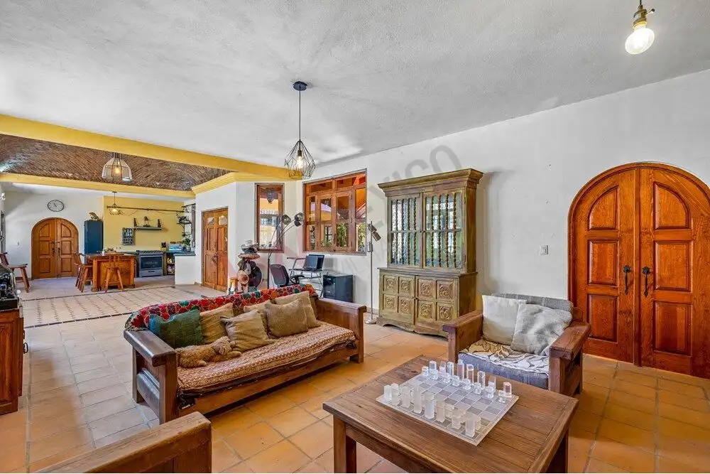 Comfortable living room with rustic wooden furniture and chess set, featuring open-plan design and t.