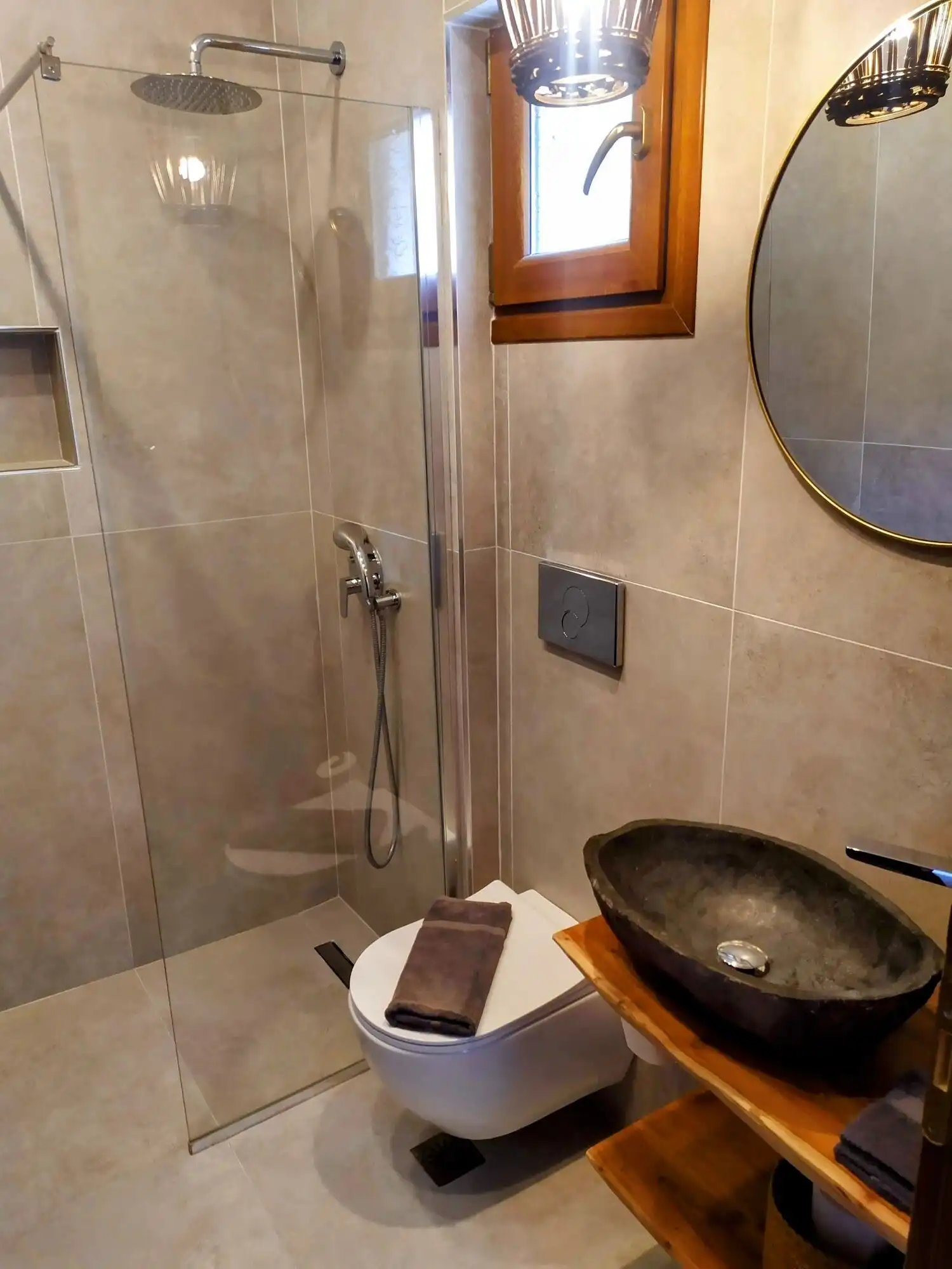 Modern bathroom with walk-in shower and sea view window.