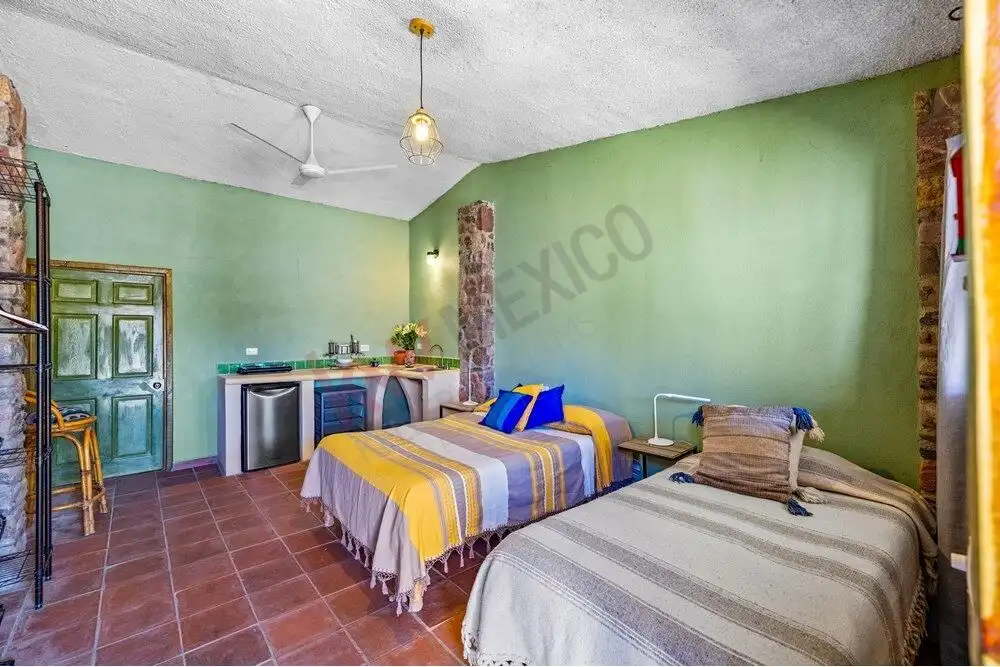 Beautiful guest bedroom with vibrant green walls and rustic decor in a large country estate.