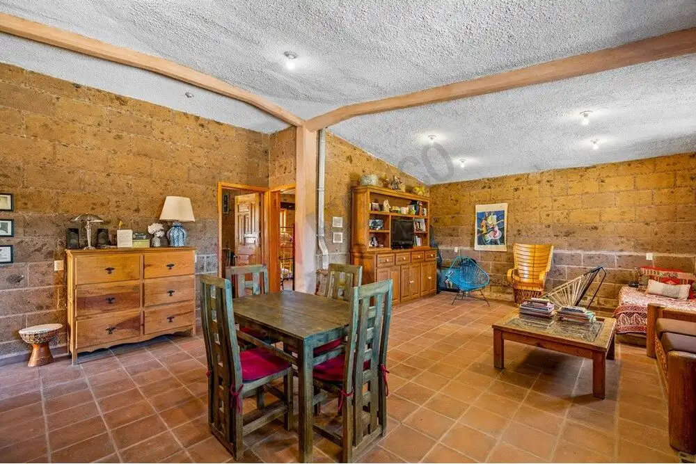Bright interior of a large country estate with rustic decor and ample seating.