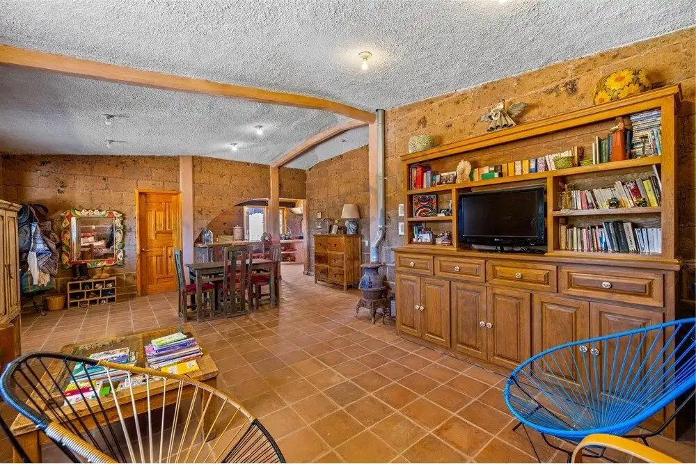 Spacious living room with rustic decor, wooden accents, and cozy furniture in a large country estate.