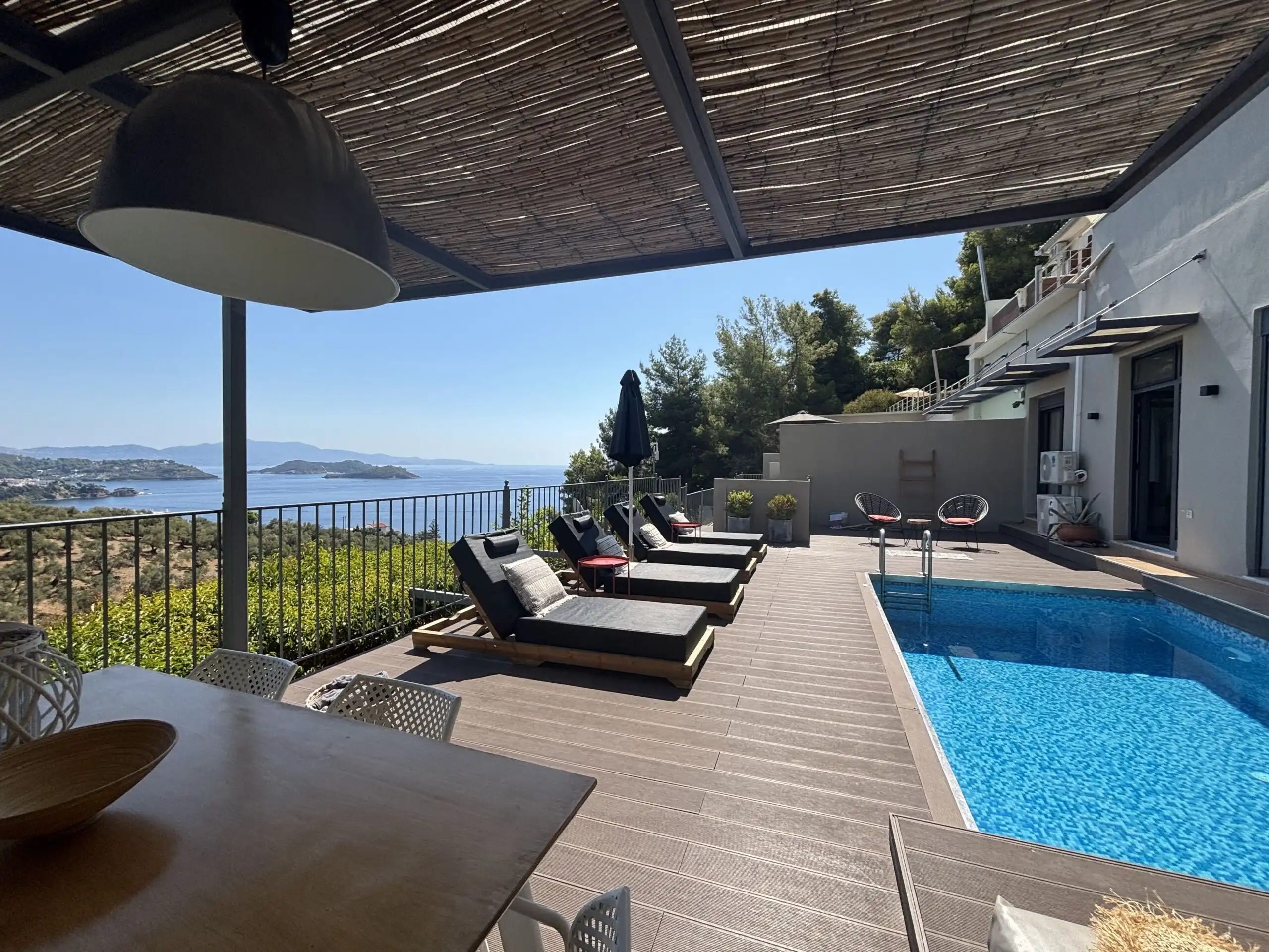 View terrace with pool and sun loungers in Skiathos, Greece.