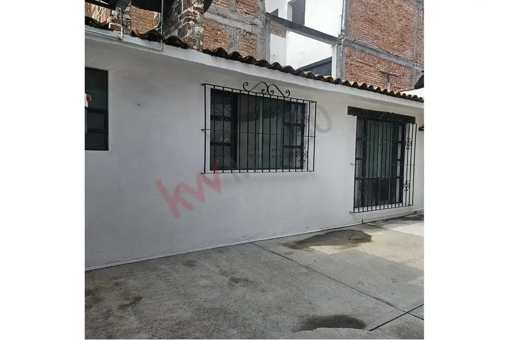 Story House Near Centro Single-story house with white exterior, black window bars, near San Miguel de Allende center.
