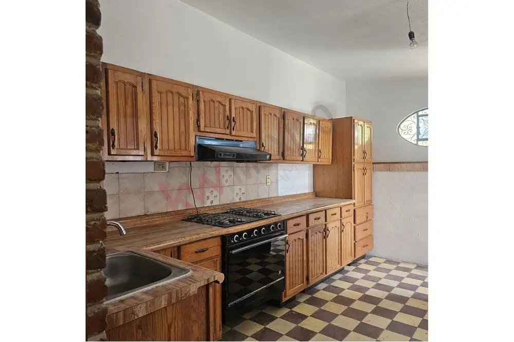 Story Kitchen in San Miguel de Allende Kitchen with wooden cabinets and checkered floor in a San Miguel de Allende home.