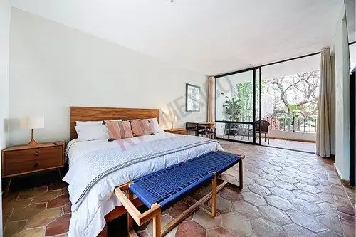 Spacious bedroom with balcony, natural light, and garden views in Colonia Guadalupe, San Miguel de A.