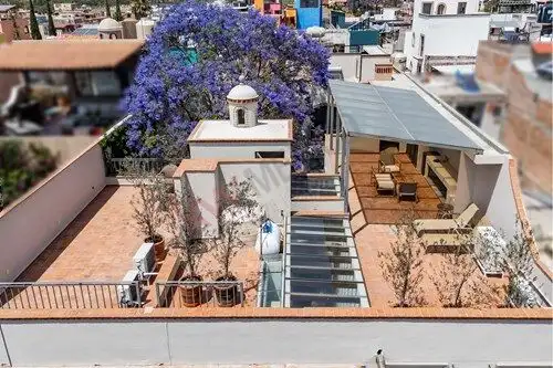 Rooftop terrace featuring outdoor seating, lush trees, and city views in San Miguel de Allende.