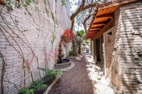 Beautiful outdoor space with brick walls and lush greenery in San Miguel de Allende.