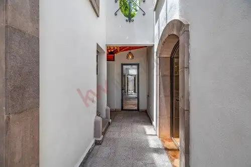 Elegant corridor of a colonial-style house with arched doorways and white walls in San Miguel de All.