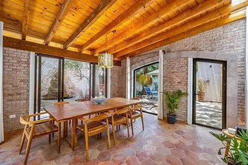 Bright indoor dining space with wooden ceiling and brick walls, perfect for family meals and gatheri.