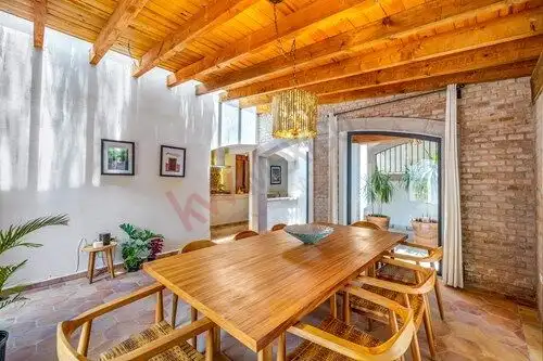 Spacious dining area featuring wooden furniture, brick walls, and natural light in a beautiful home.