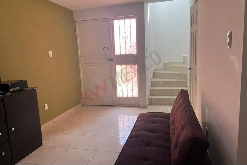 Home for Sale in San Miguel de Allende Cozy living room with door to the entrance and staircase in Guadalupe Mexiquito.