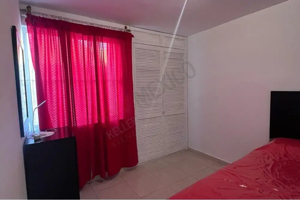 Cozy 2-Bedroom Home in Guadalupe Mexiquito Interior view of a bedroom with pink curtains and a red bedspread in San Miguel de Allende.