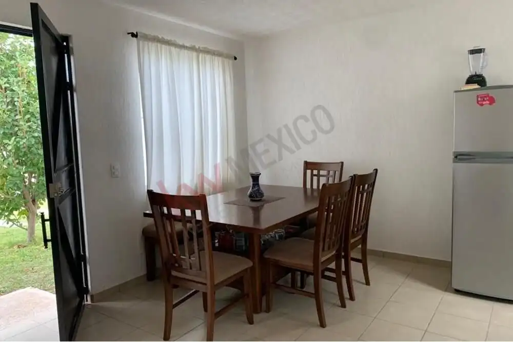 Cozy Dining Area in San Miguel de Allende Bright interior with wooden dining table and chairs near a large window.