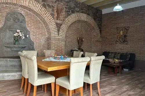 Elegant dining and living area with exposed brick walls in Rancho Los Labradores.