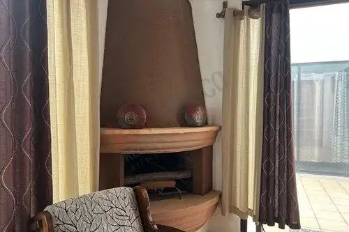 Cozy living room with a warm fireplace and elegant curtains, perfect for relaxing in a serene home s.