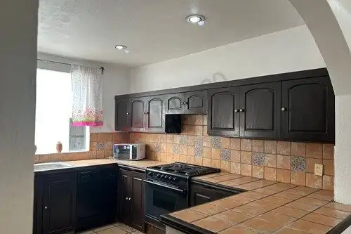Bright kitchen with dark cabinetry and tiled countertops in Rancho Los Labradores, San Miguel de All.