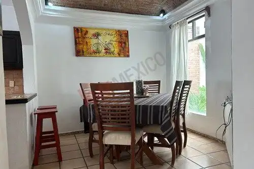 Bright dining room with wooden table and chairs in a single-level home in San Miguel de Allende.