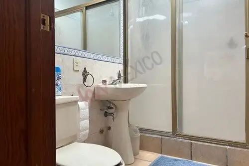 Bathroom with shower stall, sink, and toilet in a cozy home in San Miguel de Allende.