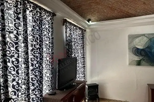 Bright living room featuring stylish black and white patterned curtains and a flat-screen TV.
