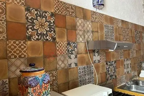 Colorful patterned kitchen tiles in a rustic home setting.