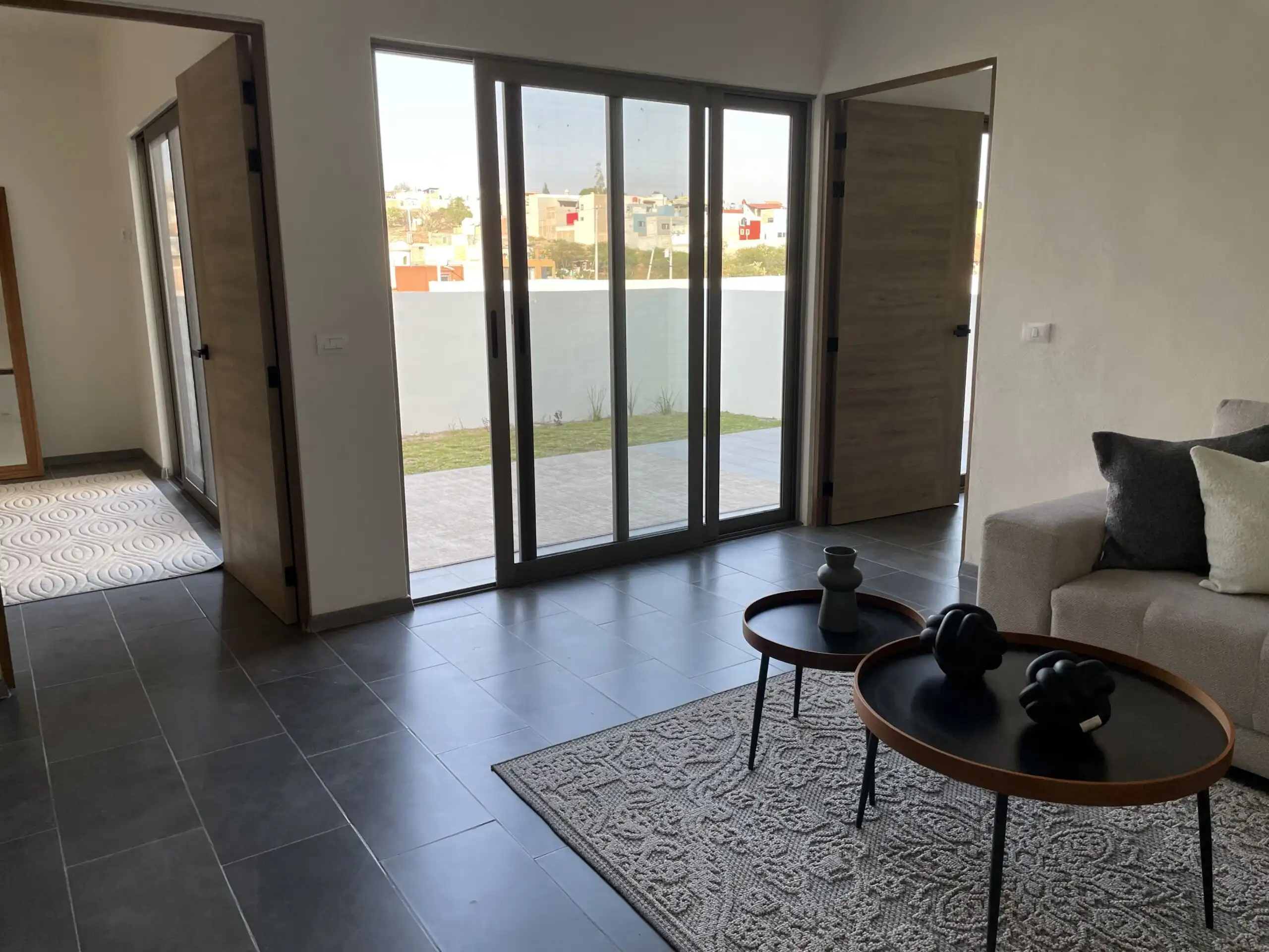 Spacious living room with large glass doors opening to a balcony in Residencial Barroco, San Miguel.