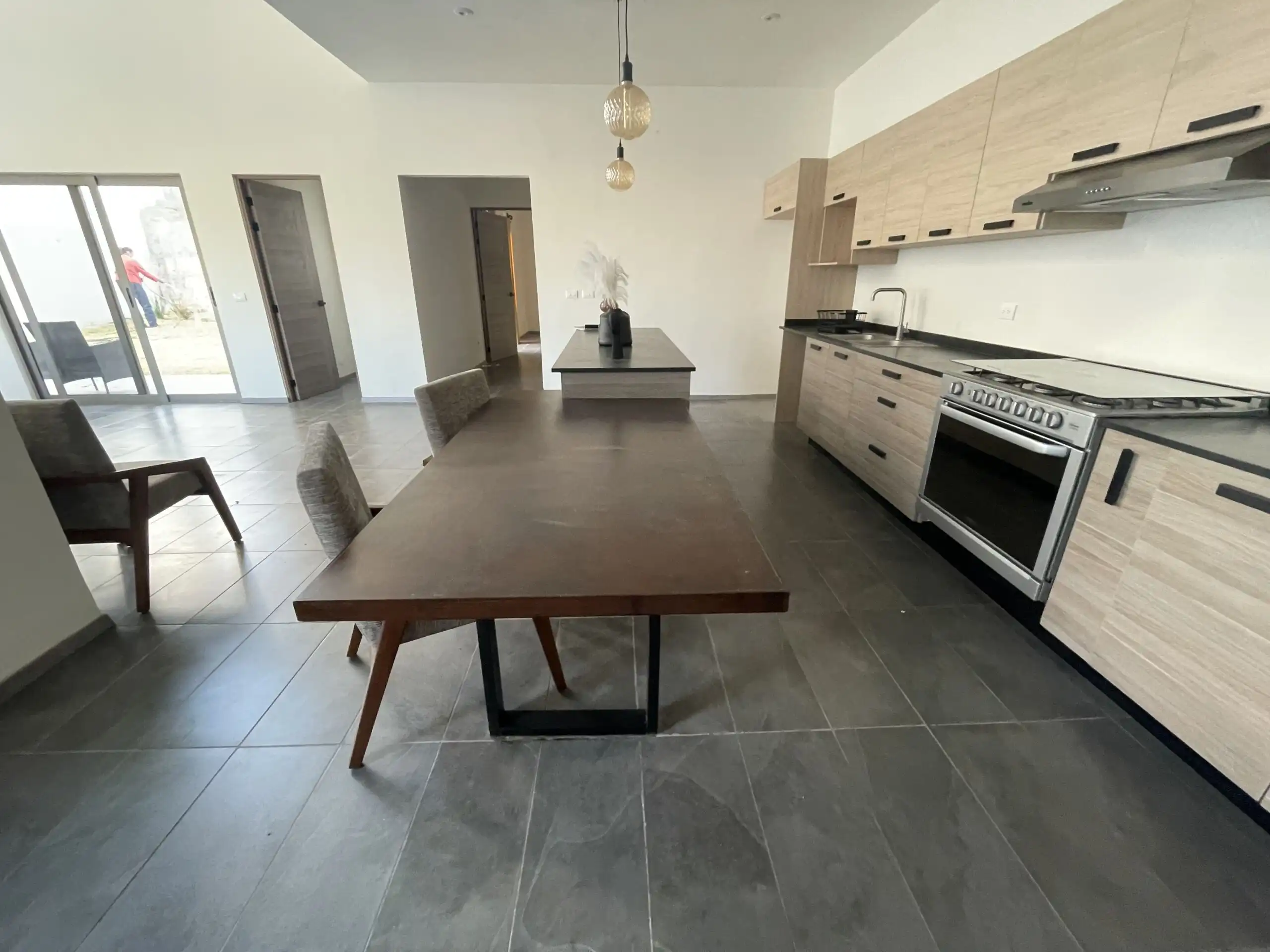 Modern Home Kitchen in Residencial Barroco Contemporary kitchen with wooden cabinets, stainless steel appliances, and a dining table in Residen.