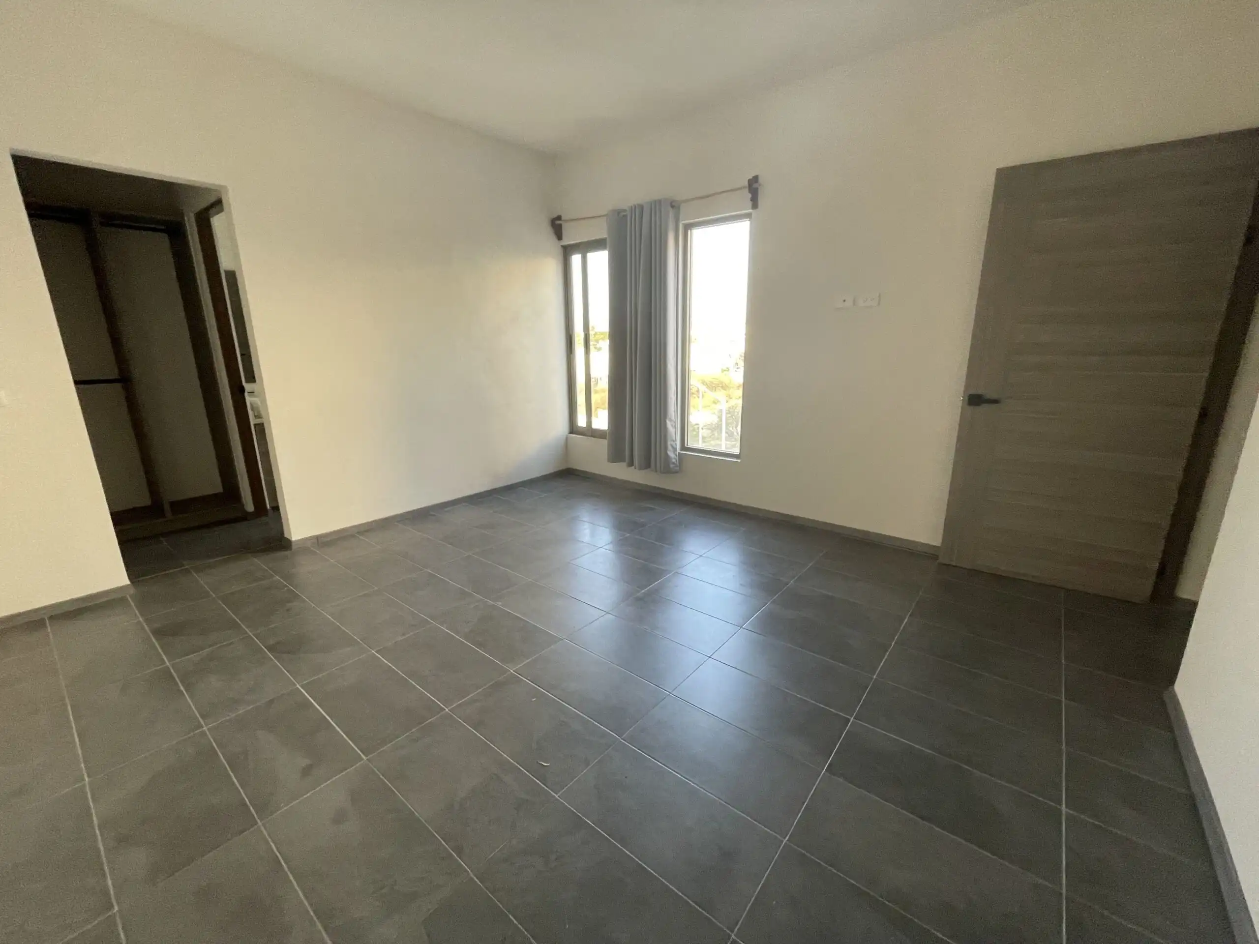 Modern Home Interior in San Miguel de Allende Spacious empty room with large windows and tiled floor in Residencial Barroco.