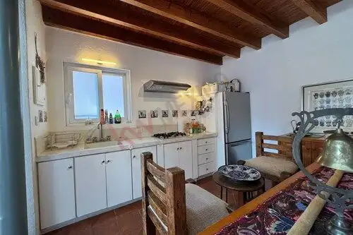 Cozy fully furnished loft kitchen in San Miguel de Allende with rustic wooden ceiling and modern app.