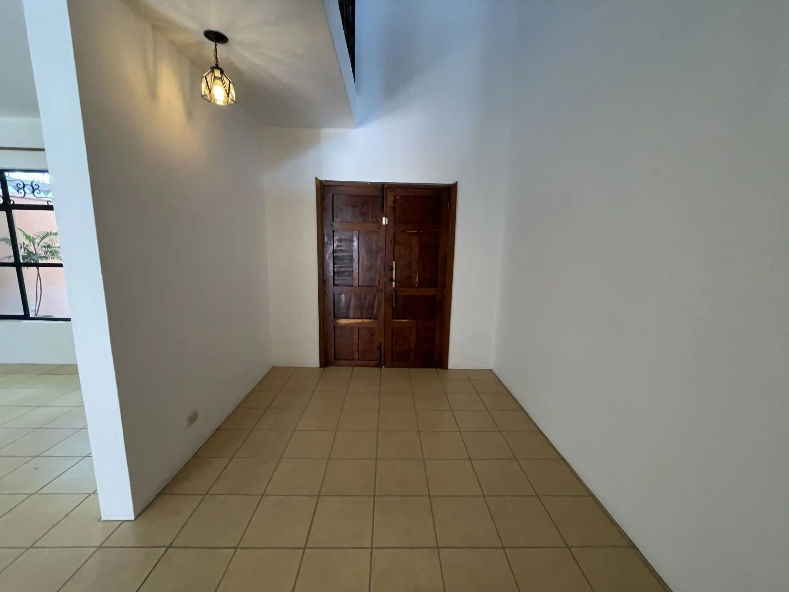 Spacious interior of Los Frailes 3-bedroom home featuring a cozy fireplace, lush garden, and rooftop.