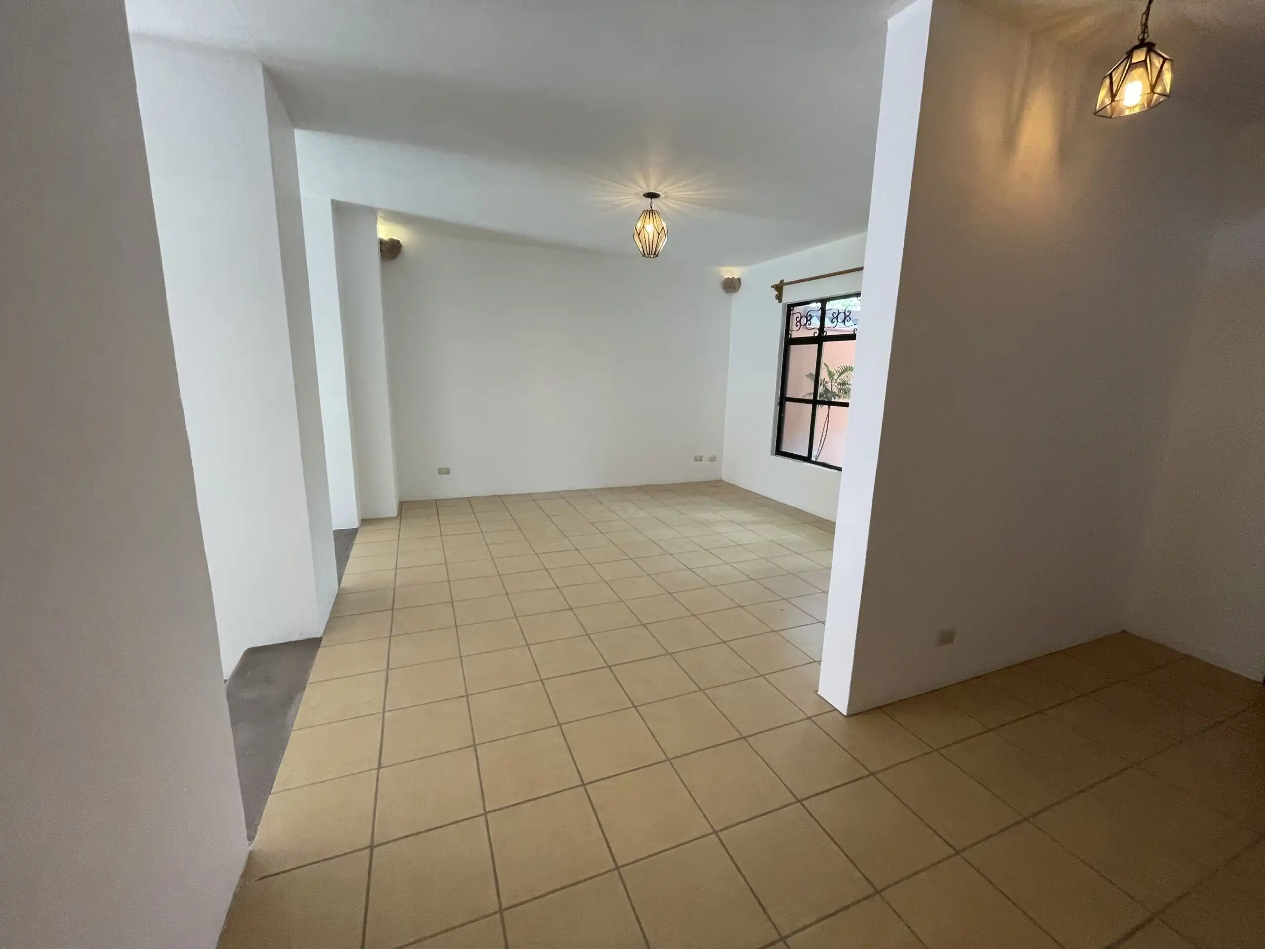 Bright living space with tiled flooring and elegant lighting fixtures.
