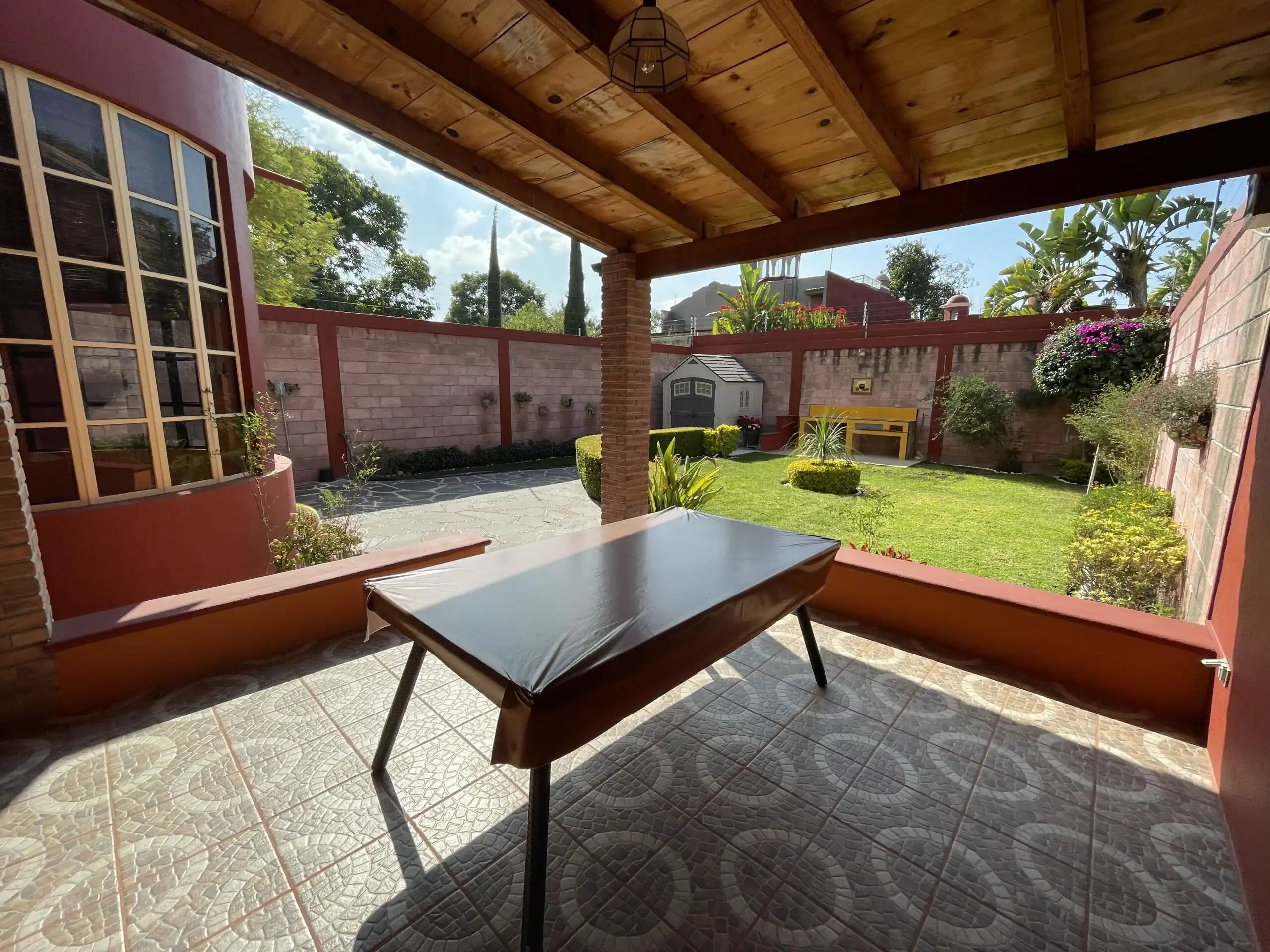 Beautiful outdoor patio with garden view and cozy fireplace in Los Frailes home.