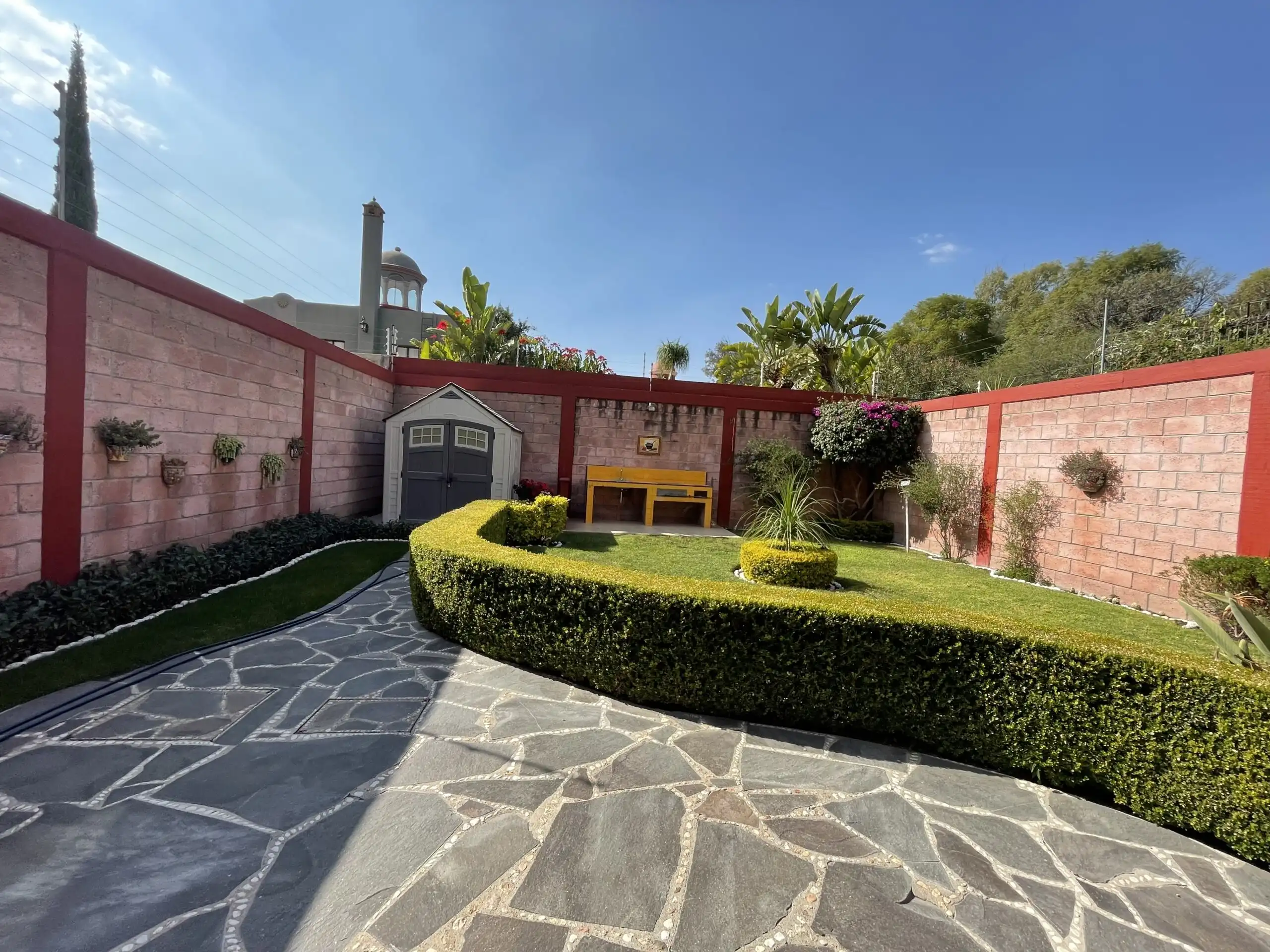 Beautiful garden with trimmed hedges, outdoor furniture, and vibrant plants in a private backyard.