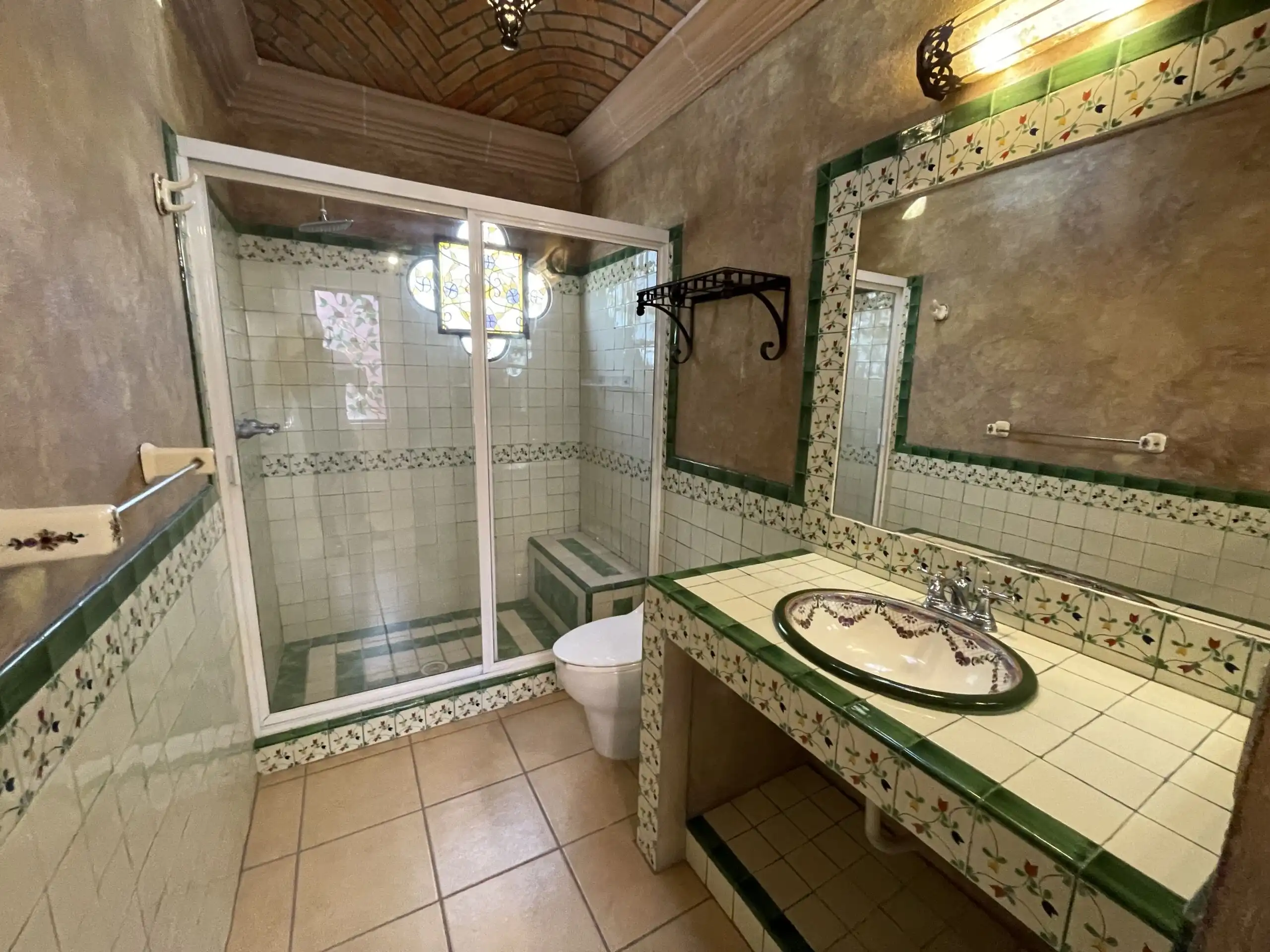 Bright bathroom featuring a tiled shower, sink, and decorative accents in a charming Los Frailes pro.