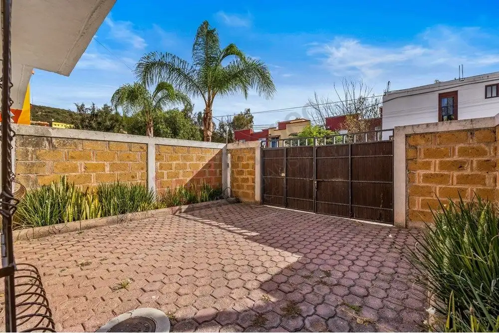 Bright outdoor patio with brick paving and lush greenery in San Miguel de Allende.