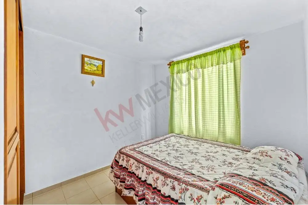 Comfortable bedroom with bright green curtains and simple decor in a charming home near Centro.