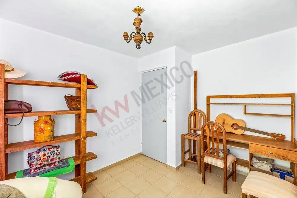 Cozy interior of a budget-friendly home close to Centro, featuring simple furnishings and a guitar f.